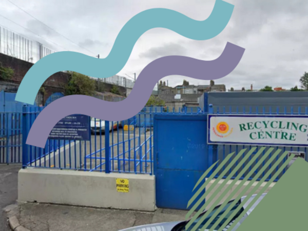 Entrance to a recycling centre with blue fencing and gates, viewed from street level. A sign reading “Recycling Centre” is visible on the right. Decorative coloured shapes overlay the top and bottom of the image.