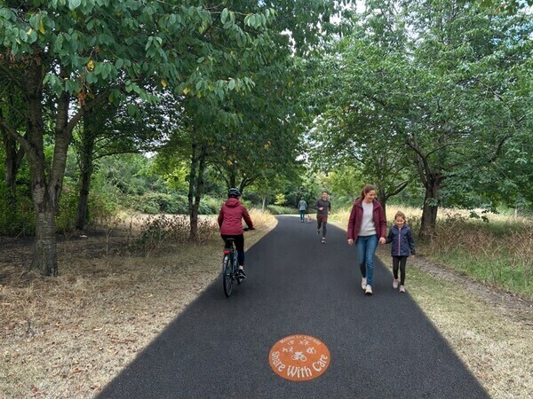 an artrist's impression of the proposed scheme shows a path with pedestrians, runners and cyclists using the shared space